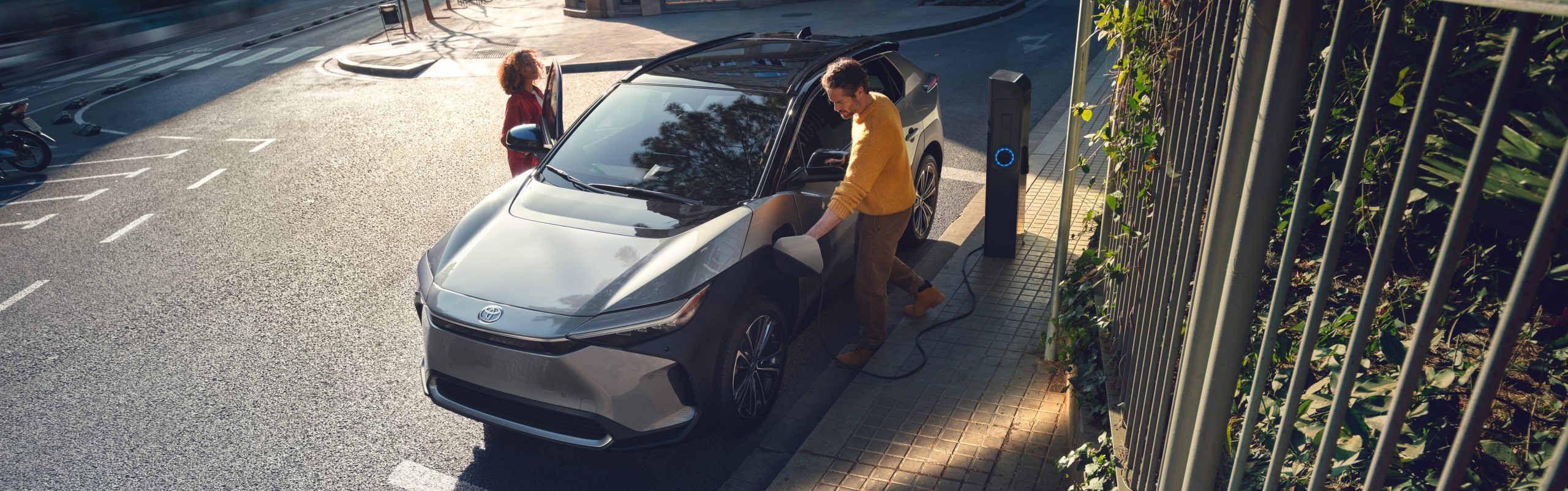 Couple plugging their Toyota battery Electric vehicle bz4Xinto charger 