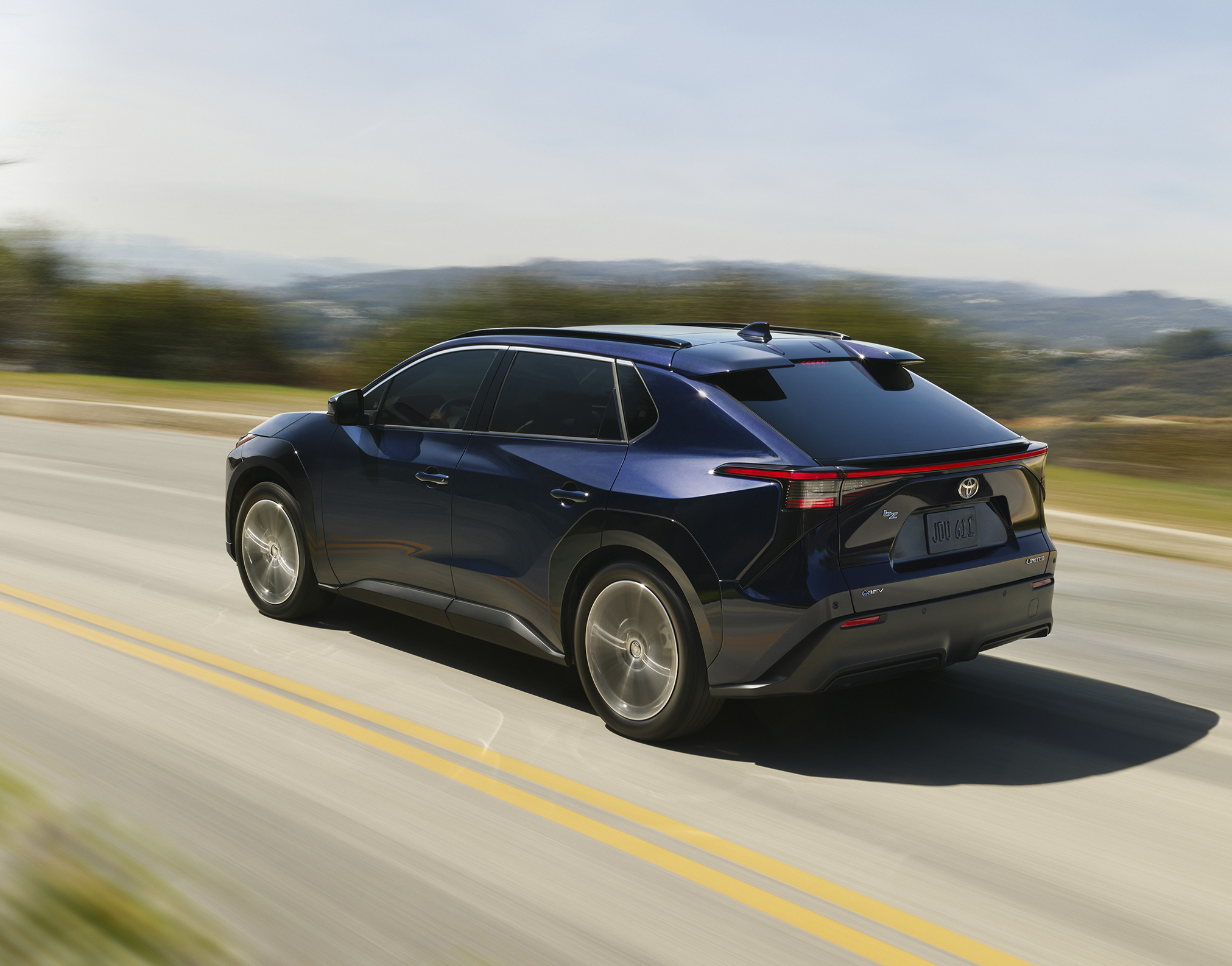 Rear blue Toyota bz driving